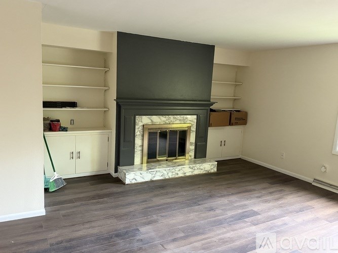 A living room with a fireplace and a grey floor.