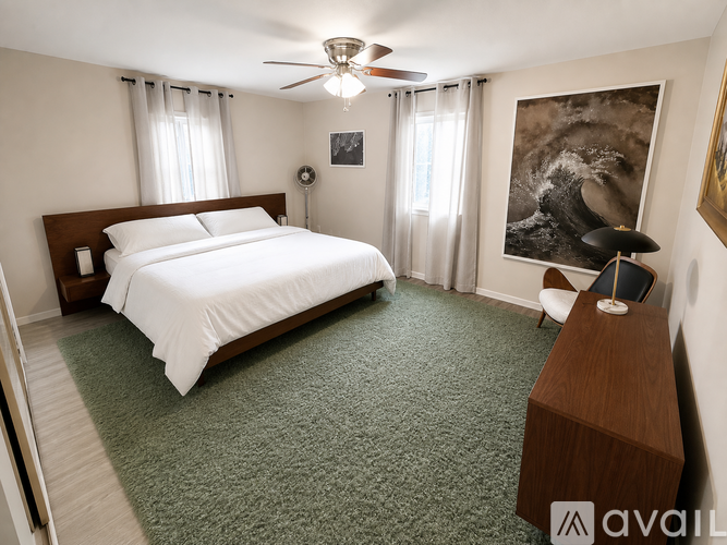 A spacious room with wooden flooring and a fireplace.