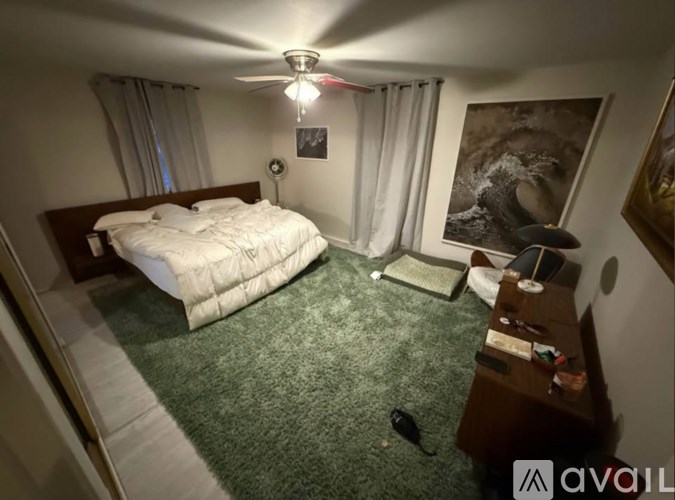 A room with a ceiling fan and two windows.