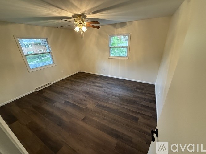 A room with wooden flooring and a ceiling fan.