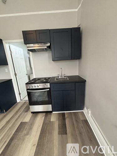 A kitchen with a stove top oven and a sink.