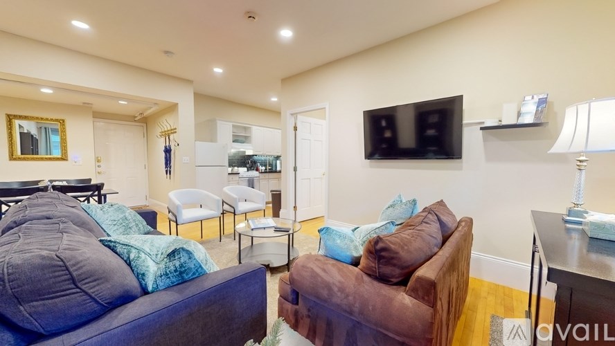 A living room with a blue couch and a brown couch.