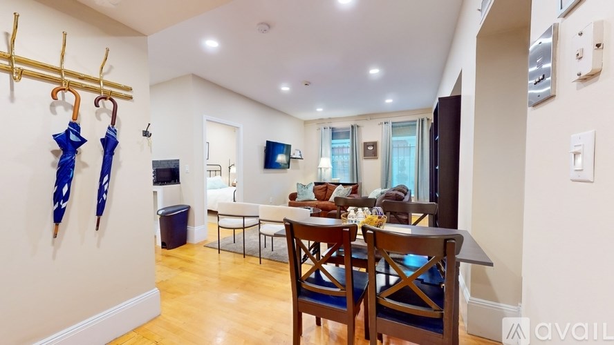 A dining room with a table set for two and a wall of windows.