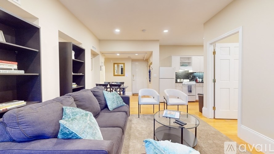 A living room with a grey couch and a glass coffee table.