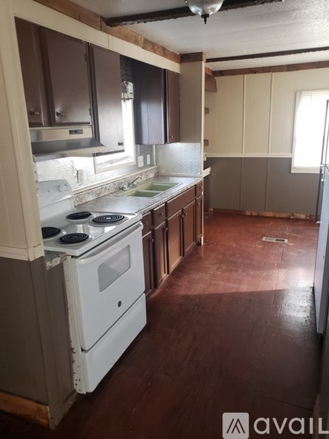 A kitchen with a white stove and wooden cabinets.