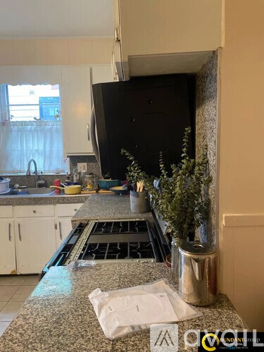 A kitchen with granite countertops and a stove top oven.