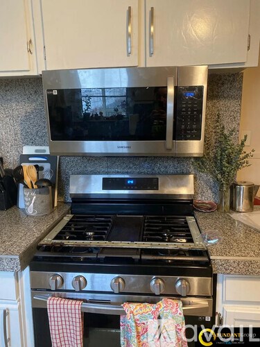 A kitchen with a stove top oven and microwave above it.