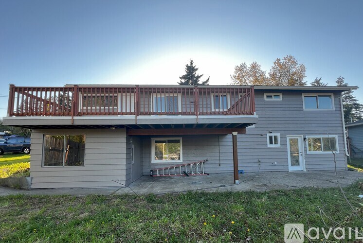 A house with a balcony and a car parked in the driveway.