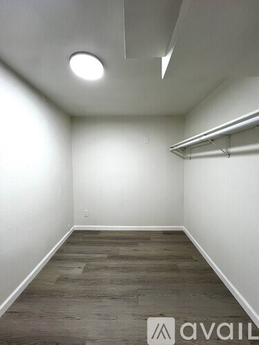 A room with a wooden floor and a white wall.