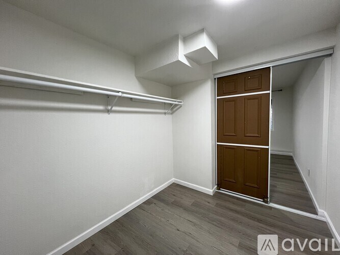A room with a wooden door and a white wall.