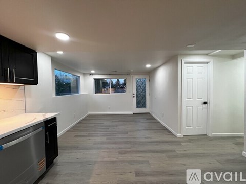 A kitchen with black cabinets and a white countertop is available.
