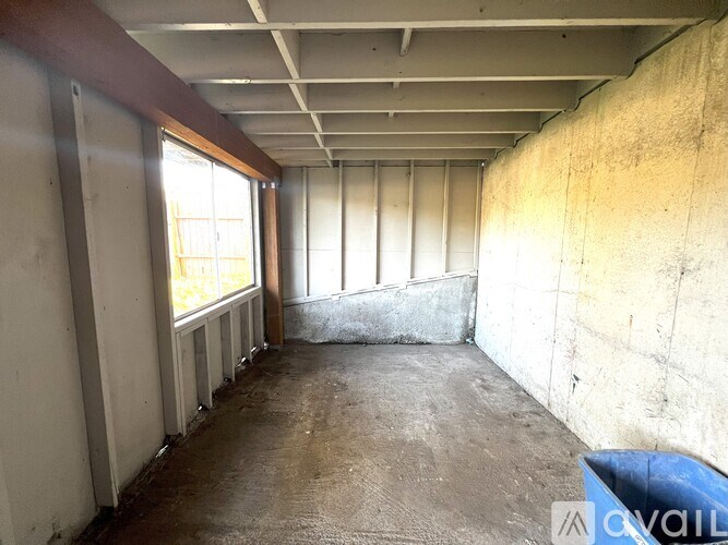 A room with a concrete wall and a window.