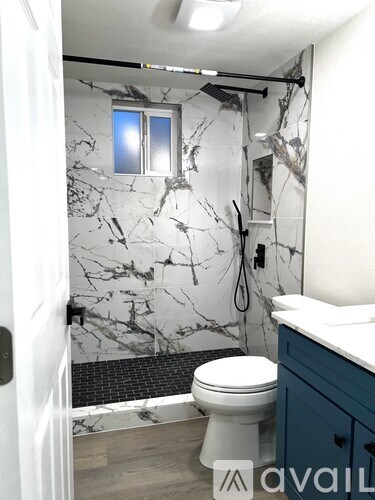 A bathroom with a marble wallpaper and a toilet.