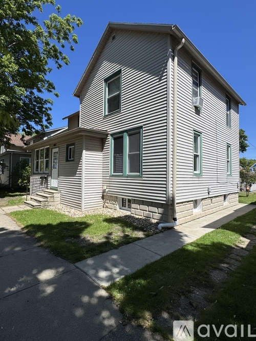 A house with a grey siding and a green window.