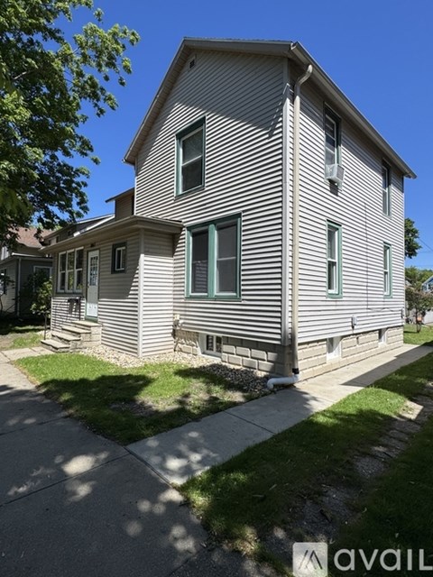 A house with a grey siding and a green window.