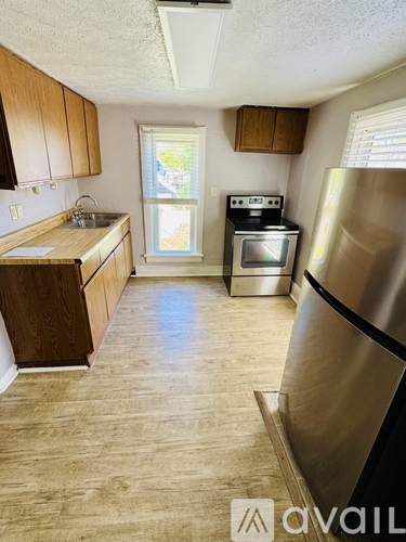 A kitchen with wooden cabinets and a stainless steel refrigerator.