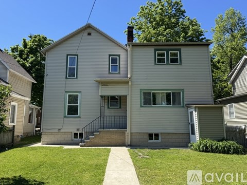 A two-story house with a front porch and a garage door.
