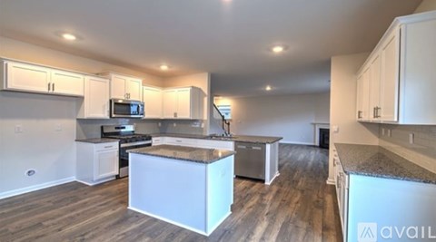 A kitchen with white cabinets and a wooden floor.
