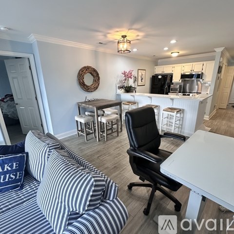A living room with a striped couch and a dining area with a white table and chairs.
