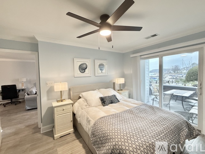 A living room with a striped couch and a ceiling fan.
