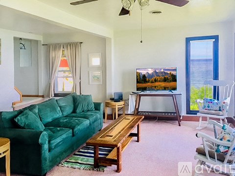 A living room with a green couch and a wooden coffee table.