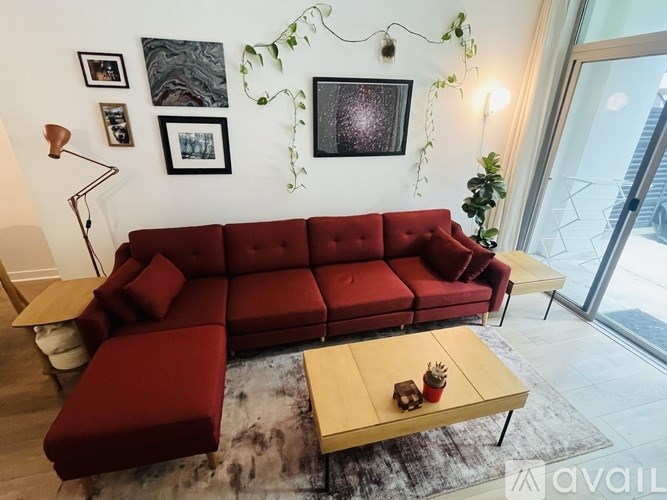 A red sofa with a wooden coffee table in front of it.