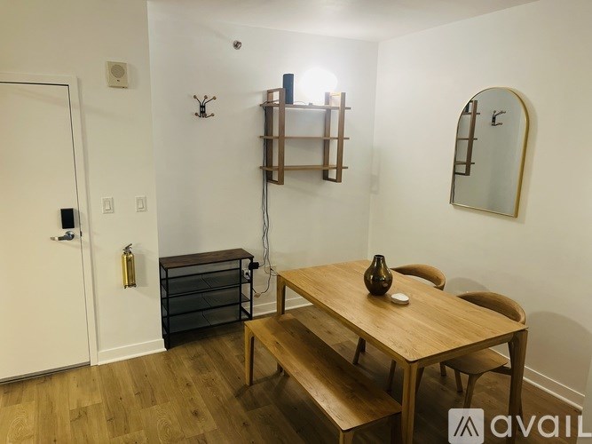 A wooden table with a vase on it and chairs around it in a room.