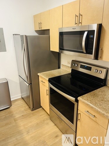 A kitchen with a stove, refrigerator, and microwave.
