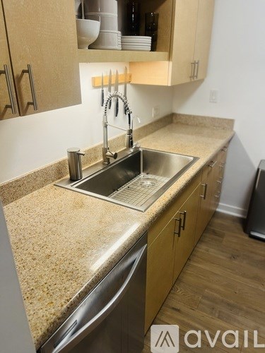 A kitchen with a granite countertop and stainless steel sink.
