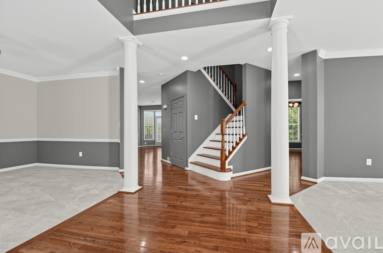 A spacious living room with a staircase leading to the upper floor.