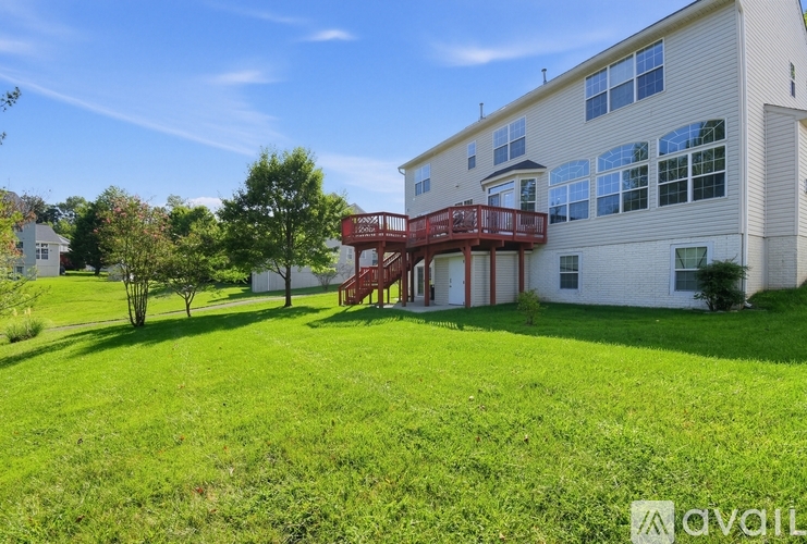 A large white building with a red deck in the backyard.