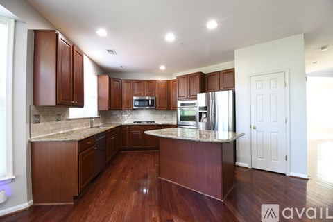 A kitchen with wooden cabinets and a marble countertop.