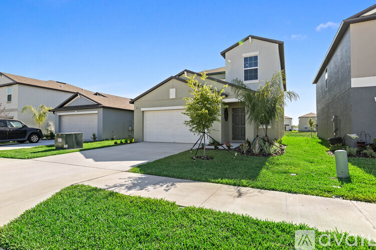 A house with a garage and a driveway in front of it.
