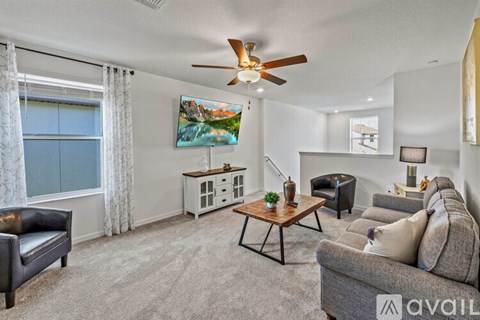 A living room with a grey couch, a wooden coffee table, and a painting on the wall.