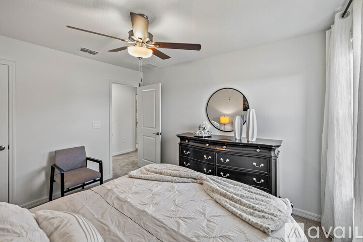 A bedroom with a bed, chair, and dresser.
