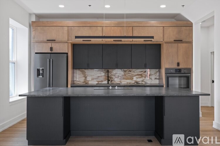 A kitchen with a black countertop and wooden cabinets.