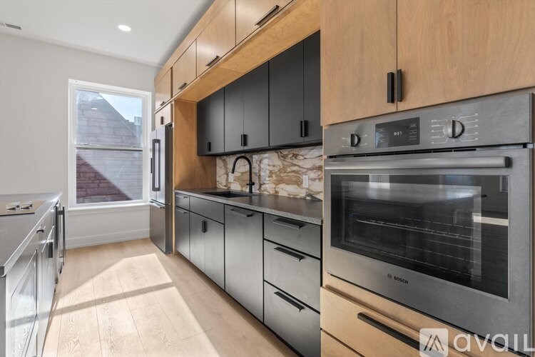 A modern kitchen with wooden cabinets and stainless steel appliances.