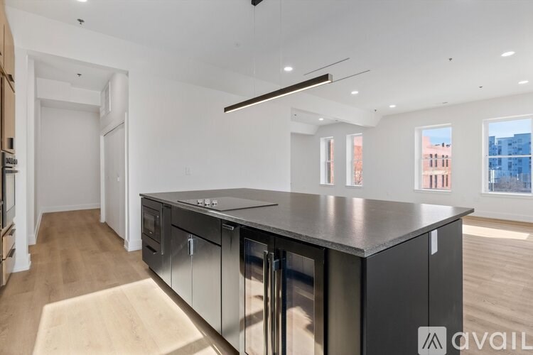 A modern kitchen with a large island and stainless steel appliances.