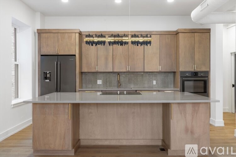 A kitchen with wooden cabinets and a stainless steel refrigerator.