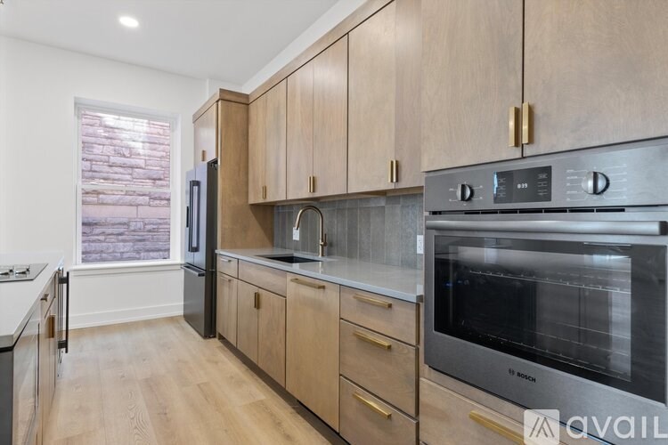 A kitchen with wooden cabinets and a stainless steel oven.