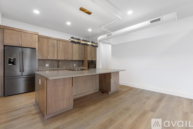 A kitchen with wooden cabinets and a stainless steel refrigerator.