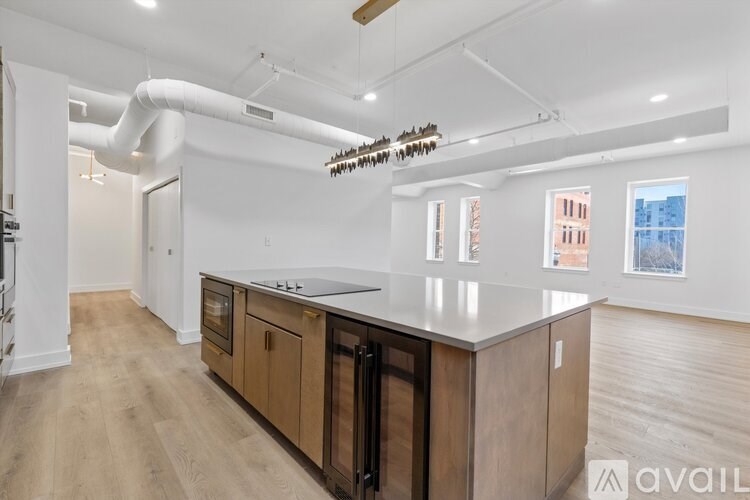A kitchen with wooden cabinets and a white countertop is available for rent.