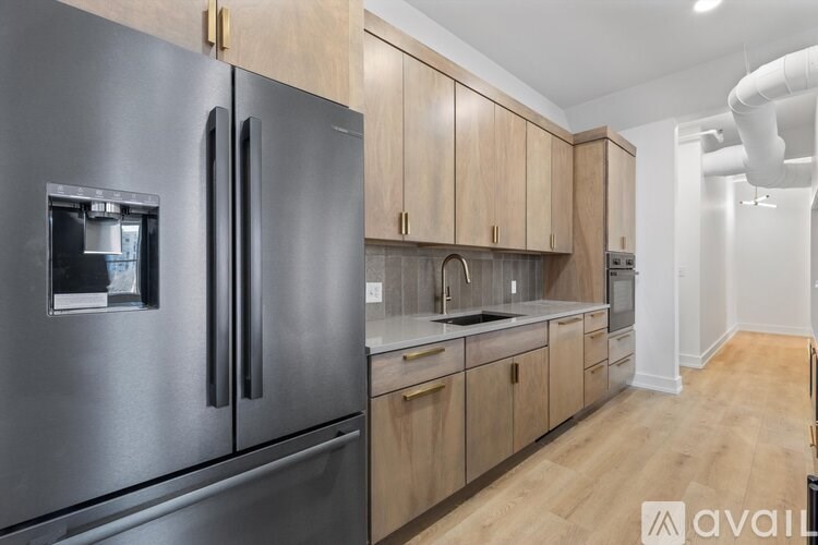 A modern kitchen with a stainless steel refrigerator and wooden cabinets.