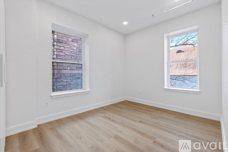 A room with a window showing a brick wall outside.