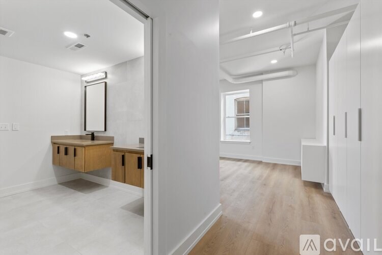 A white room with a wooden vanity and a mirror.