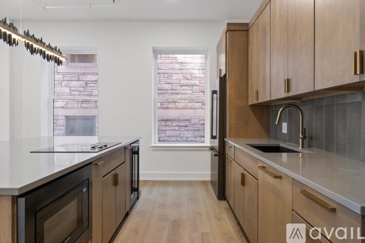 A kitchen with wooden cabinets and a black refrigerator.