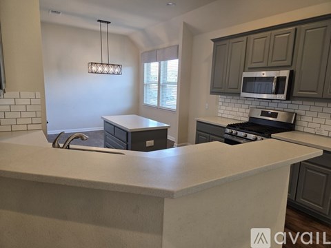 A kitchen with a white countertop and a microwave above it.