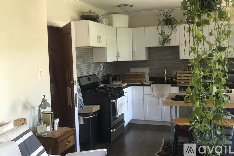 A kitchen with black countertops and white cabinets.