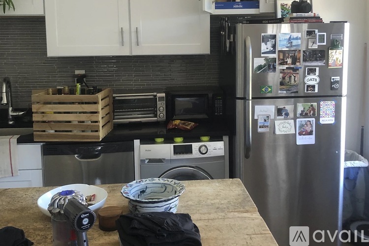 A kitchen with white cabinets and a black countertop.