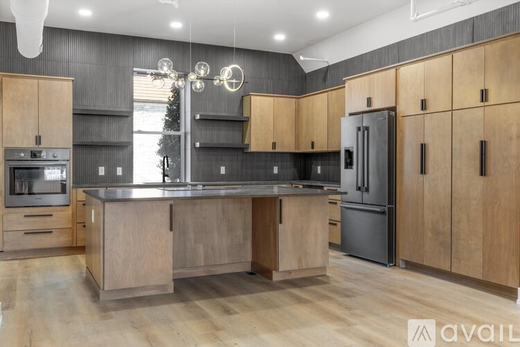 A modern kitchen with wooden cabinets and a large island.